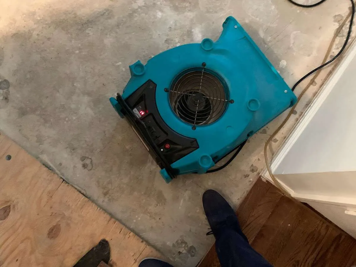 Air mover drying subfloor during Commercial Water Damage Restoration in Lunenburg